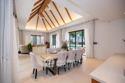 Luxurious open-plan living and dining area with vaulted ceiling and pool view.