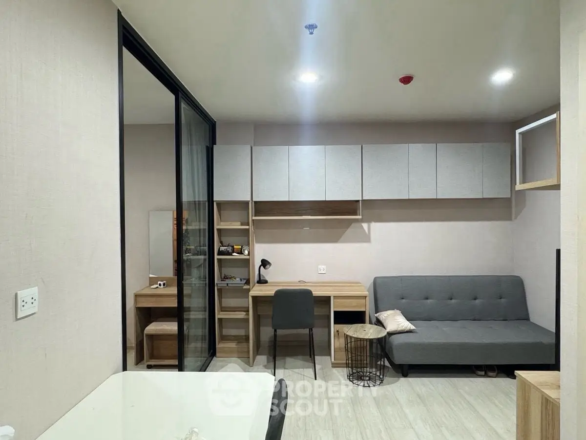 Modern living room with sleek furniture and workspace, perfect for urban living.