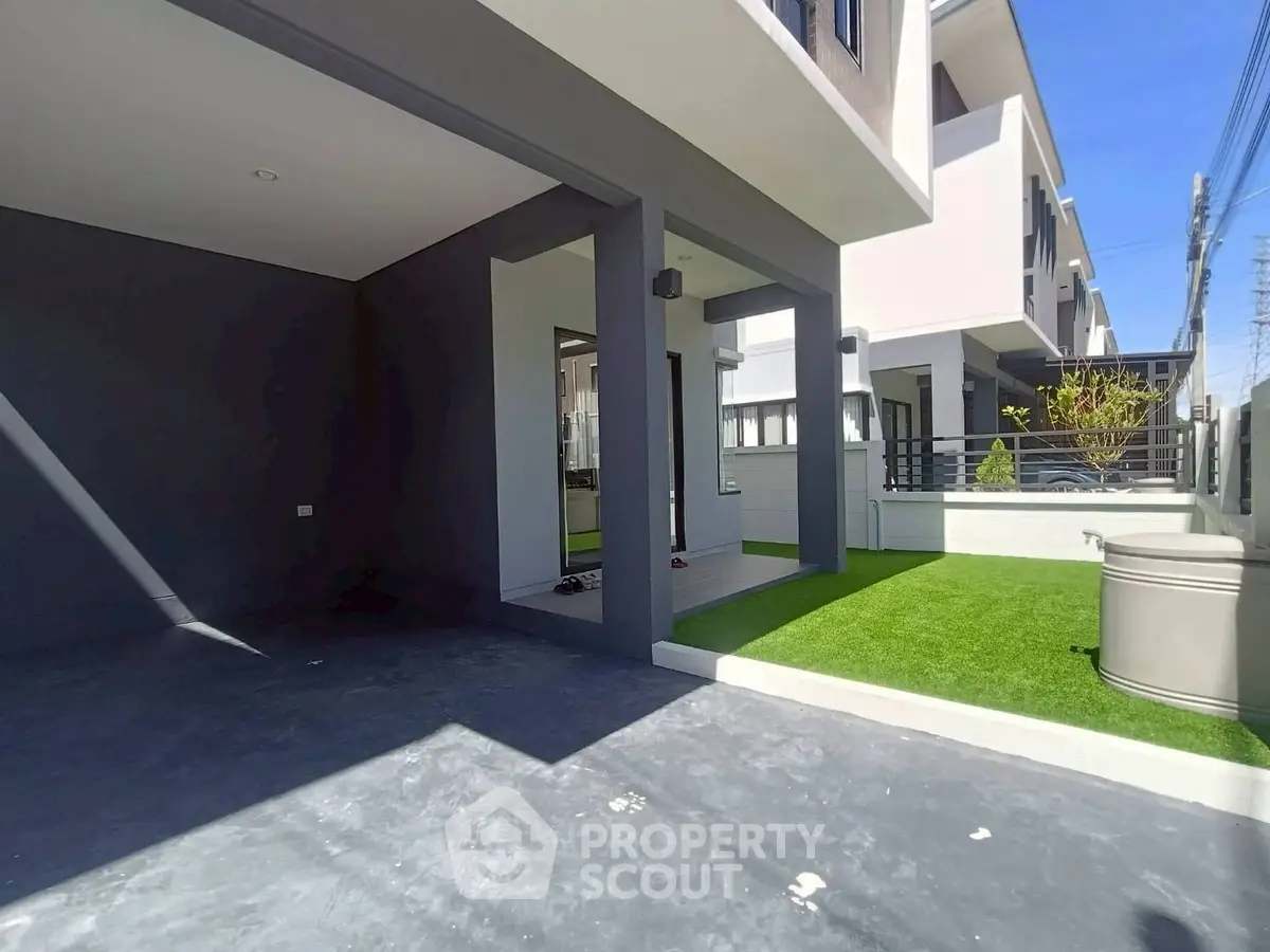 Modern townhouse exterior with sleek design and artificial grass lawn