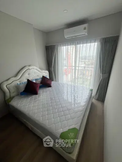 Cozy bedroom with large window and air conditioning, perfect for relaxation.