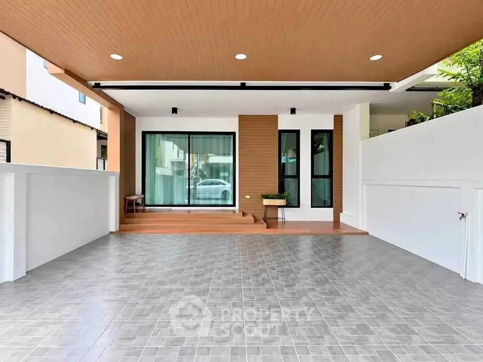 Modern home entrance with spacious tiled driveway and wooden accents