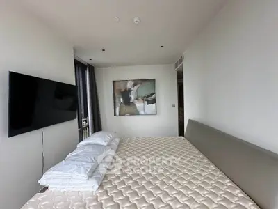 Modern bedroom with minimalist decor and wall-mounted TV in a stylish apartment.