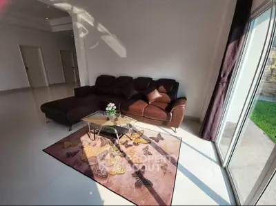 Spacious living room with elegant brown sofa and butterfly-themed rug, featuring ample natural light.