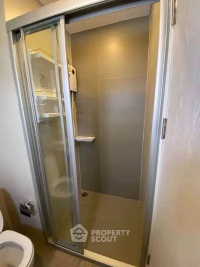 Modern bathroom with sleek shower enclosure and neutral tiles, perfect for a contemporary home.