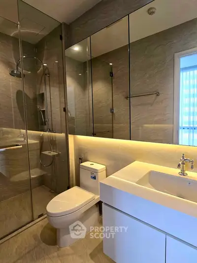 Modern bathroom with glass shower and sleek fixtures in a luxury apartment.
