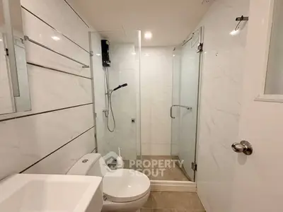Modern bathroom with glass shower and sleek white fixtures