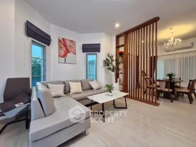 Modern living room with elegant decor and open dining area, featuring stylish furniture and ambient lighting.