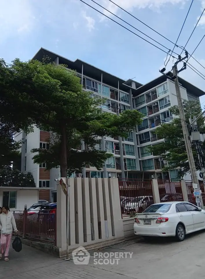 Modern apartment building with lush greenery and ample parking space