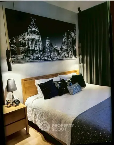 Stylish bedroom with elegant decor and cozy ambiance, featuring a large bed and artistic wall art.