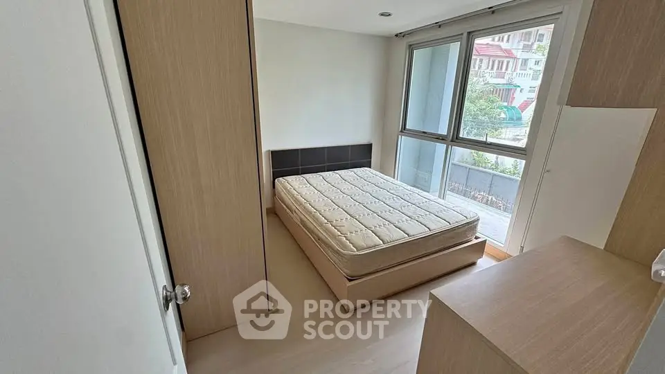 Bright bedroom with large windows and minimalist design in modern apartment.