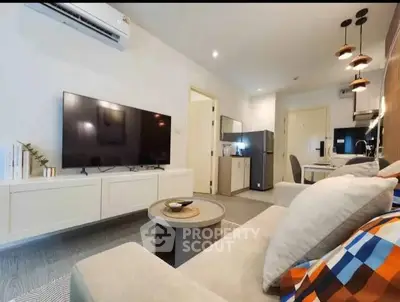Modern living room with sleek design, featuring a large TV, cozy sofa, and stylish lighting.