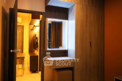 Modern bedroom with stylish wooden wardrobe and illuminated vanity mirror