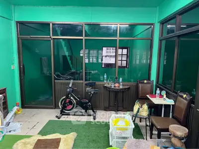 Spacious living area with exercise bike and vibrant green walls