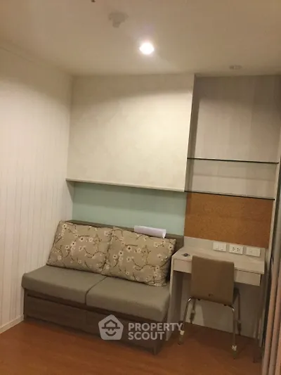 Cozy study nook with built-in desk and comfortable seating in modern apartment.