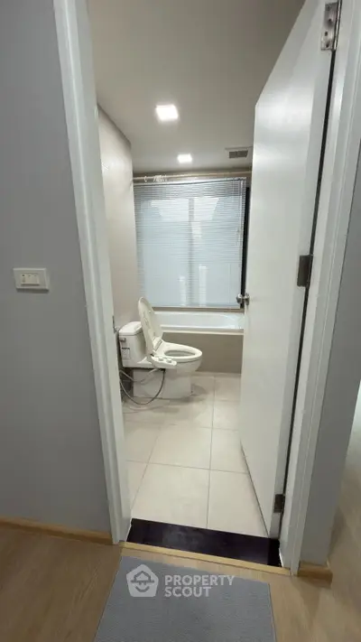 Modern bathroom with sleek design and bathtub in contemporary apartment.