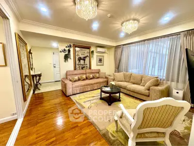 Elegant living room with plush sofas, hardwood floors, and stylish chandeliers in a cozy apartment.