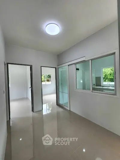 Spacious modern interior with sleek tile flooring and large windows for natural light.