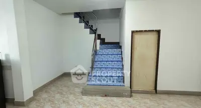 Spacious interior with modern staircase and tiled flooring, ideal for customization.