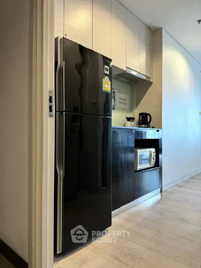 Modern kitchen with sleek black appliances and light wood cabinetry