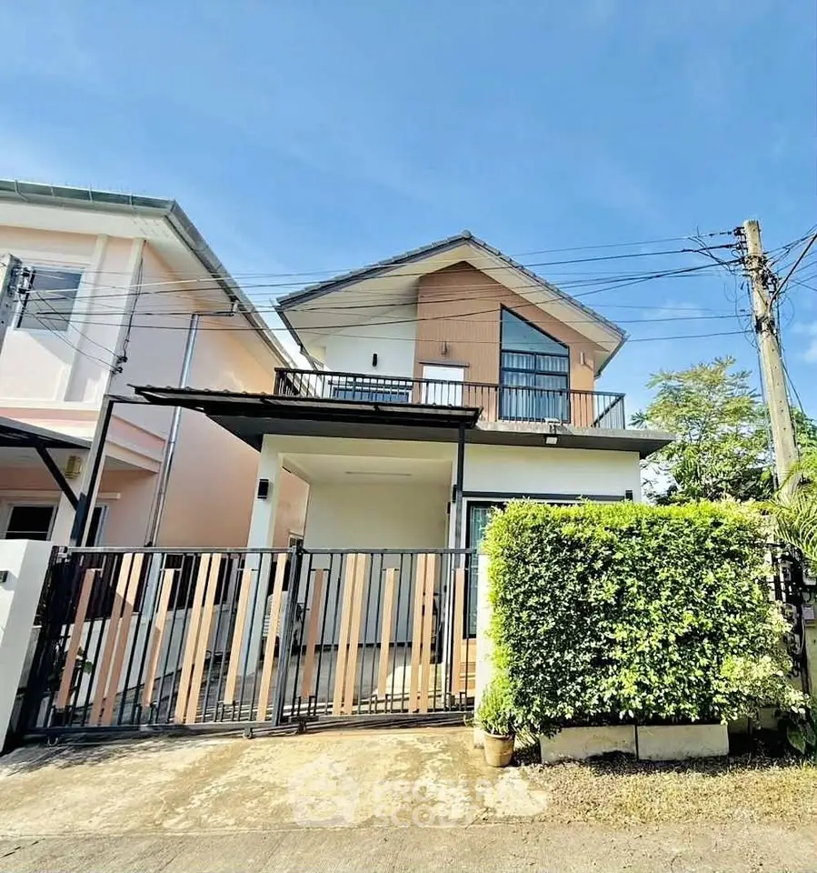 Charming two-story house with modern design and gated entrance in a sunny neighborhood.