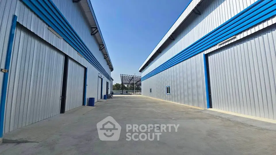 Spacious industrial warehouse exterior with blue accents and large open area.