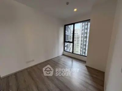 Spacious empty room with large window and city view, perfect for customization.