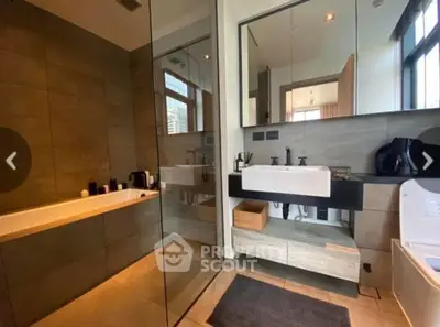 Modern bathroom with sleek design, featuring a bathtub and large mirror, perfect for relaxation.