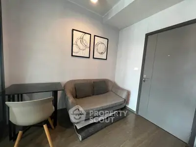 Cozy modern living room with stylish sofa and artwork, perfect for relaxation.