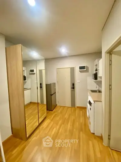 Modern apartment interior with mirrored wardrobe and wooden flooring