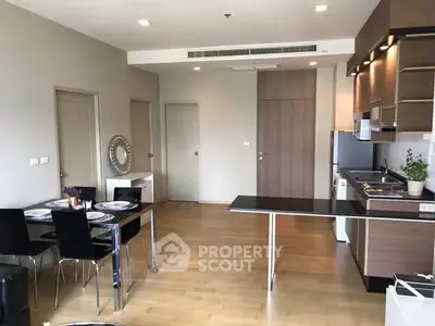 Modern open-plan kitchen and dining area with sleek design and wooden flooring.