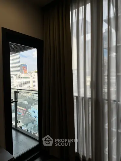 Modern apartment with city view from balcony, floor-to-ceiling windows and elegant curtains.