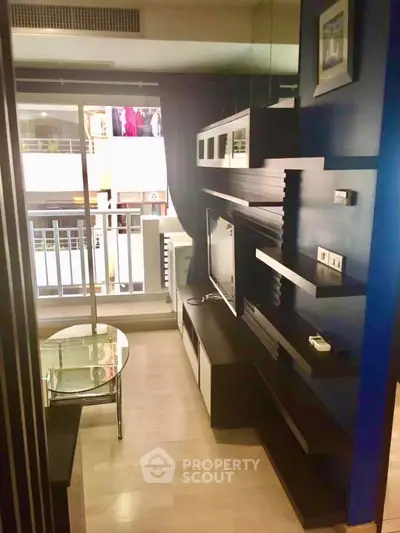 Modern living room with sleek shelving and glass table, featuring a balcony view.