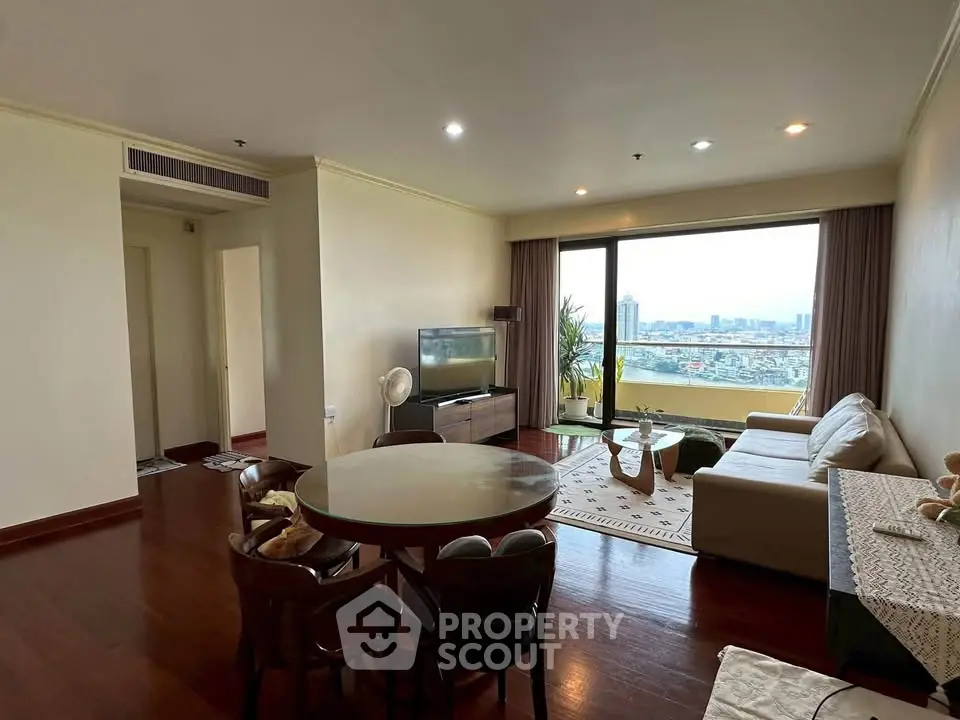 Spacious living room with city view, elegant furniture, and natural light in modern apartment.