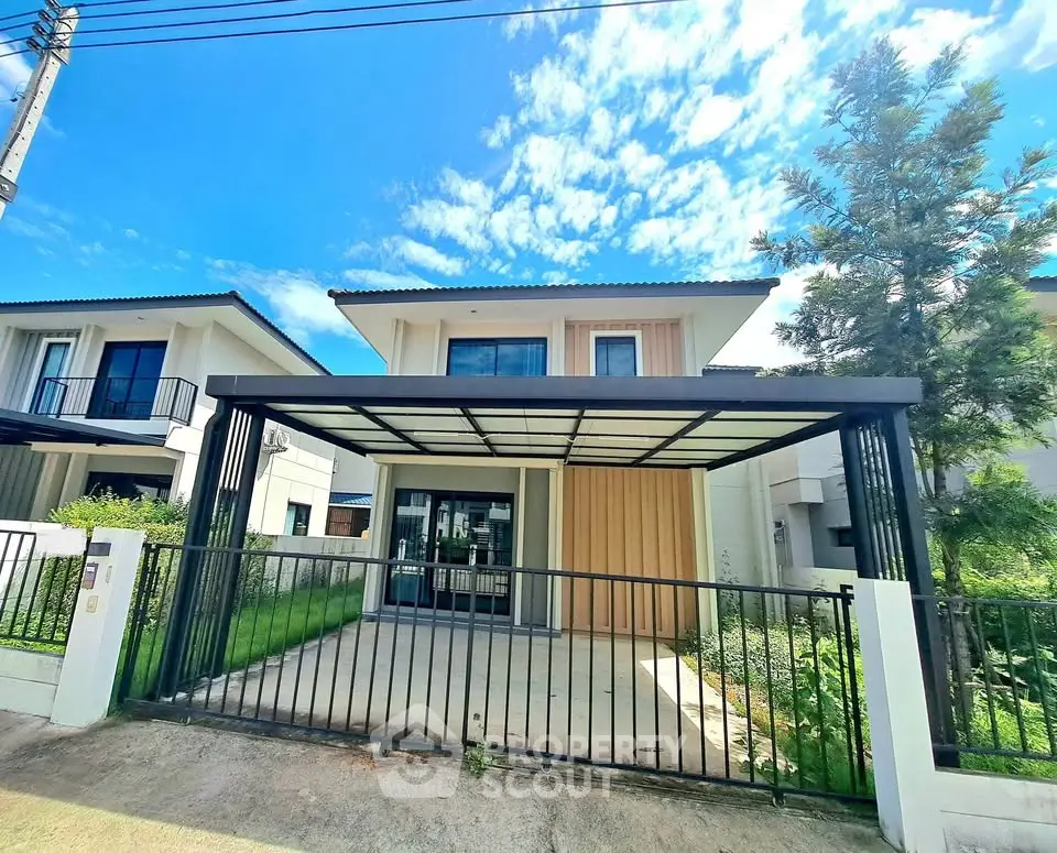 Modern two-story house with carport and lush greenery under a clear blue sky.