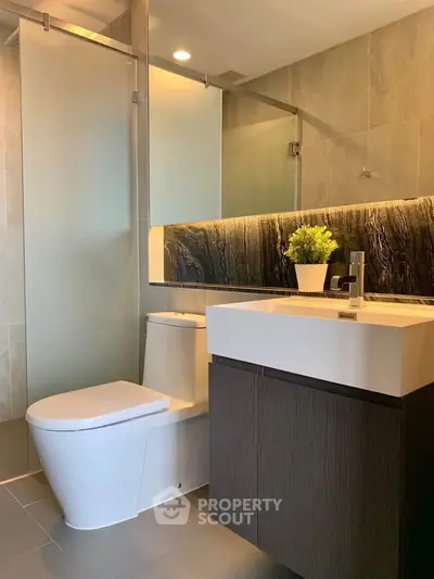 Modern bathroom with sleek fixtures and elegant design, featuring a stylish vanity and glass shower enclosure.