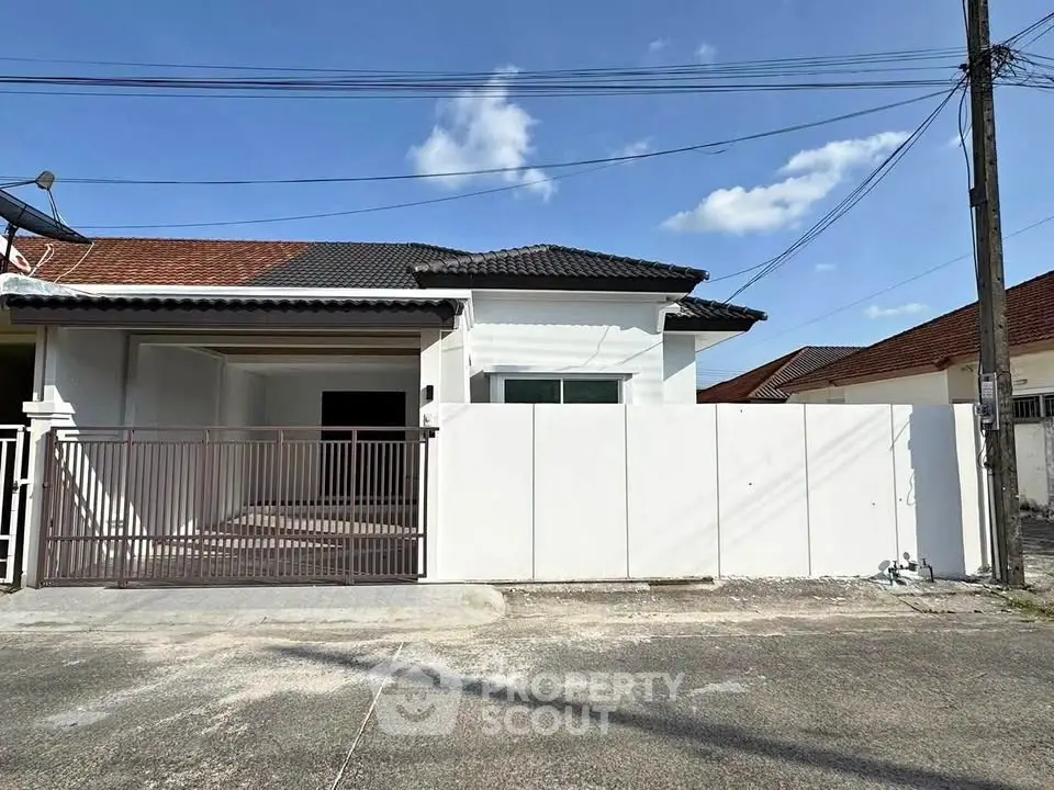Charming single-story home with gated entrance and tiled roof in a serene neighborhood.
