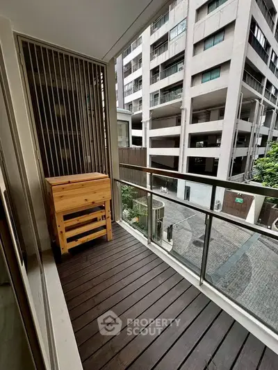 Charming balcony with wooden flooring and urban view in modern apartment complex.