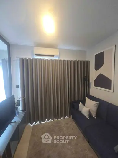 Cozy living room with modern decor and air conditioning, perfect for relaxation.