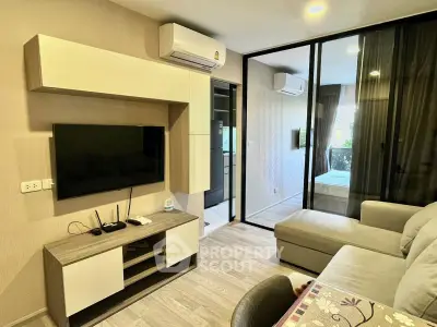 Modern living room with sleek furniture and large TV, featuring a cozy ambiance and stylish decor.