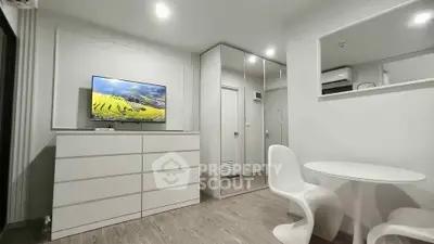 Modern living room with sleek white furniture and mirrored wardrobe