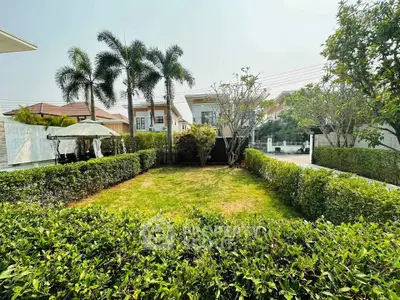 Charming residential garden with lush greenery and modern houses in the background.