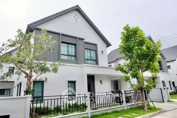 Modern two-story house with sleek design and lush greenery
