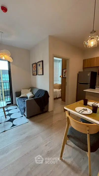 Modern open-plan living room with cozy dining area and balcony access in stylish apartment.