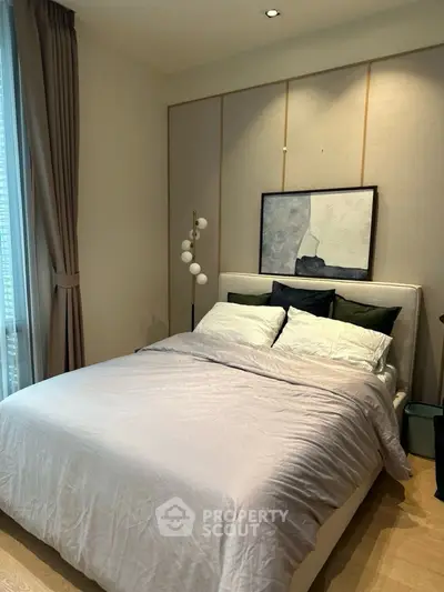 Elegant bedroom with modern decor and soft lighting, featuring a cozy bed and stylish artwork.