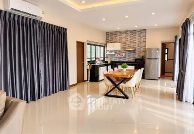 Spacious open-plan living and dining area with modern kitchen and large windows.