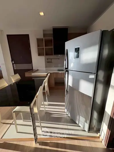 Modern kitchen with sleek refrigerator and dining area in stylish apartment