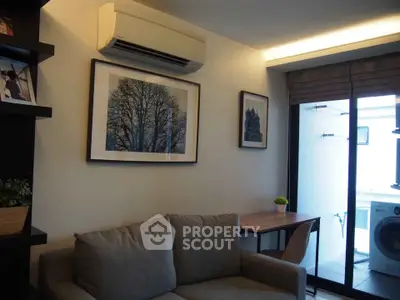 Modern living room with air conditioning and balcony access, featuring stylish decor and natural light.