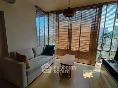 Bright living room with floor-to-ceiling windows and modern furnishings, offering a cozy and inviting atmosphere.