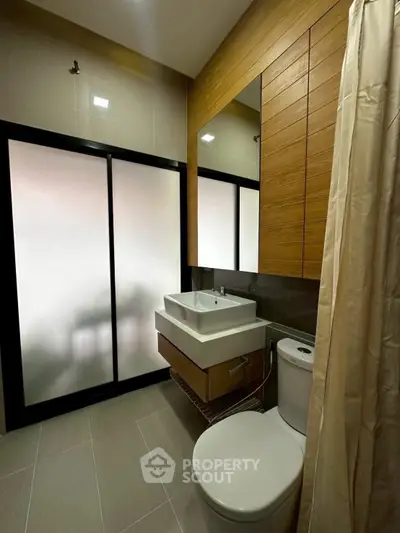 Modern bathroom with sleek fixtures and frosted glass door