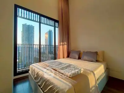 Modern bedroom with large window offering stunning city views in a high-rise apartment.